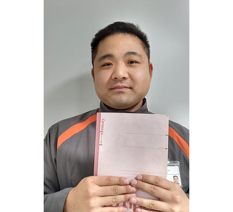ノートを持つ上野さんの写真