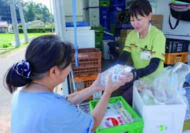 コープデリ宅配の担当者が組合員に配達する様子