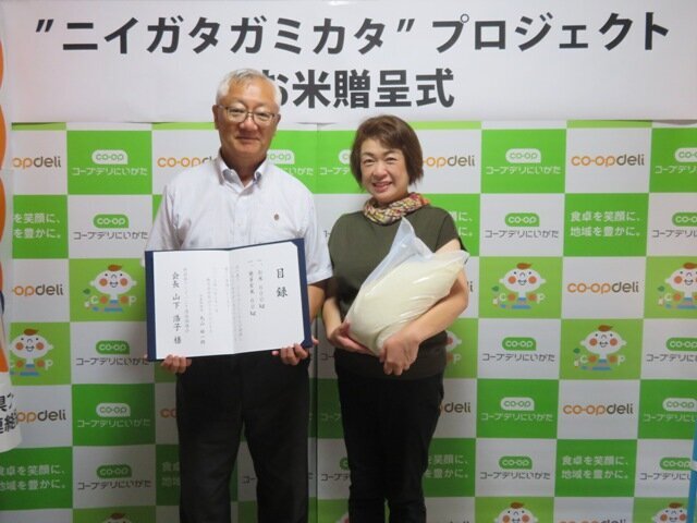 丸山ライスビジネスの丸山代表から、新潟県フードバンク連絡協議会の山下会長（右）へお米を贈呈した様子