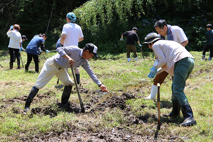 田んぼを耕す参加者の様子